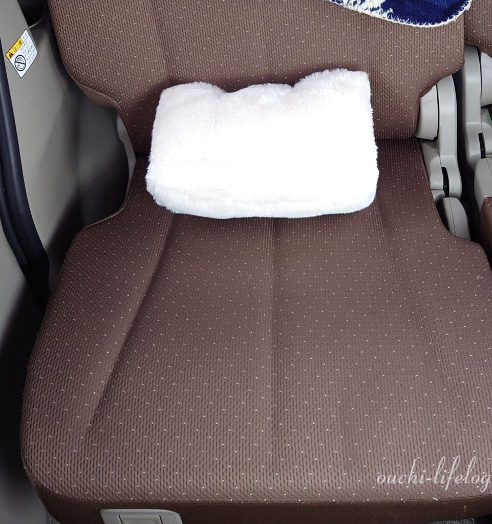 3COINSで買った【トライアングルクッション】を折りたたんで車に置いてみた写真